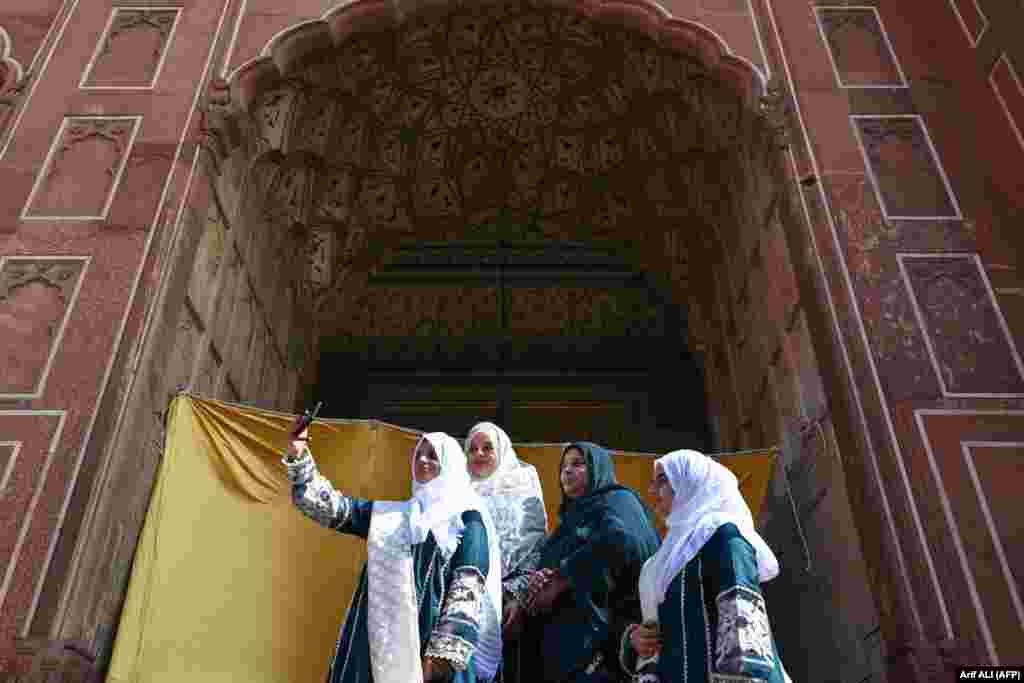 Qadınlar Lahorda (Pakistan) Badşahi camisinde namazdan soñ foto çıqara. Qurban bayramı – İslâm taqviminiñ eñ büyük bayramlarından biridir