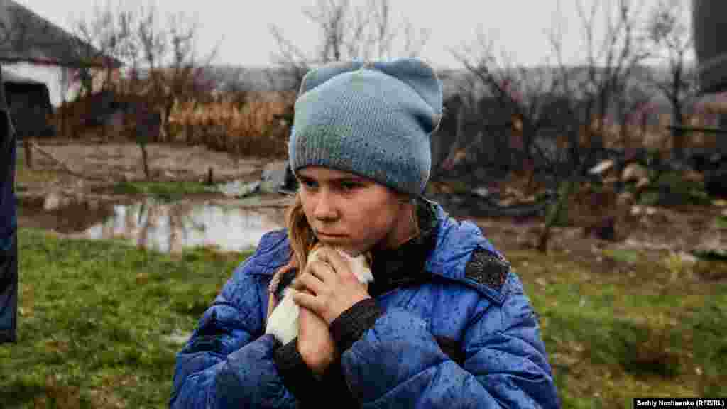 9-летняя Софья держит в руках свою морскую свинку во время эвакуации из Макеевки, города в Луганской области на востоке страны, 19 ноября 2022 года