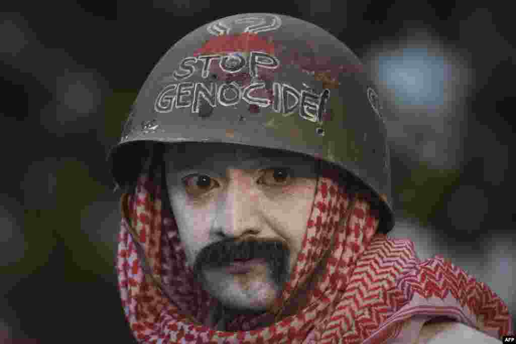 یک فعال حامی فلسطینی‌ها در تجمع اعتراضی در شهر باندونگ در اندونزی علیه عملیات اسرائیل در نوار غزه که روی کلاهش نوشته «نسل‌کشی را متوقف کنید»، ۱۹ اردیبهشت