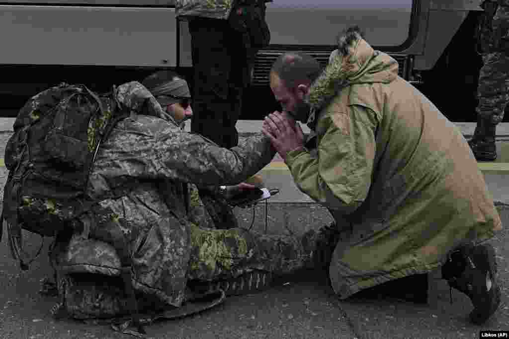 Un bărbat sărută mâna unui soldat ucrainean pentru a-i mulțumi, în gara din Kramatorsk, regiunea Donețk, Ucraina.