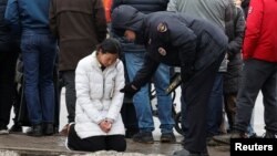 A Russian police officer approaches a woman outside the Crocus City Hall in the Moscow region following a deadly attack at the concert venue on March 22.