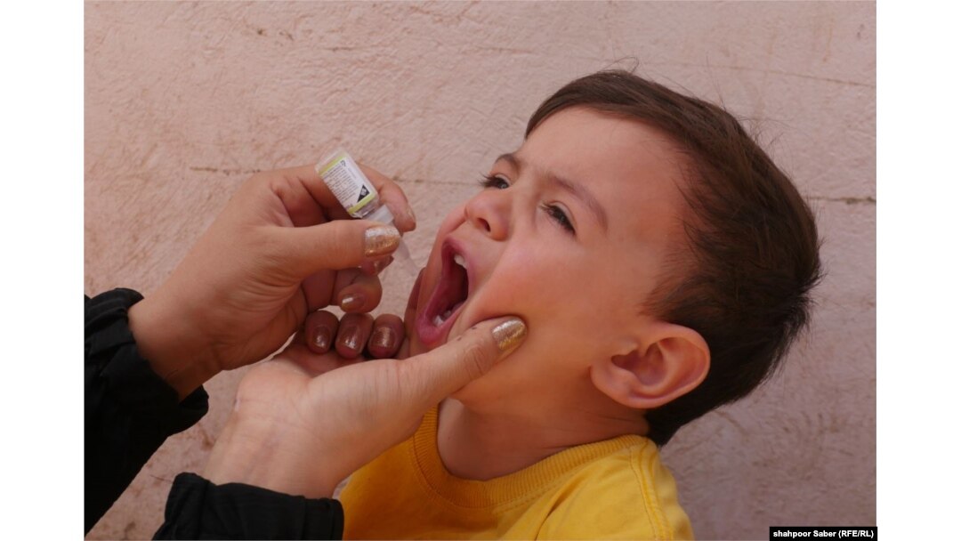 An Afghan health-care worker gives a polio vaccine to a child in the western city of Herat.