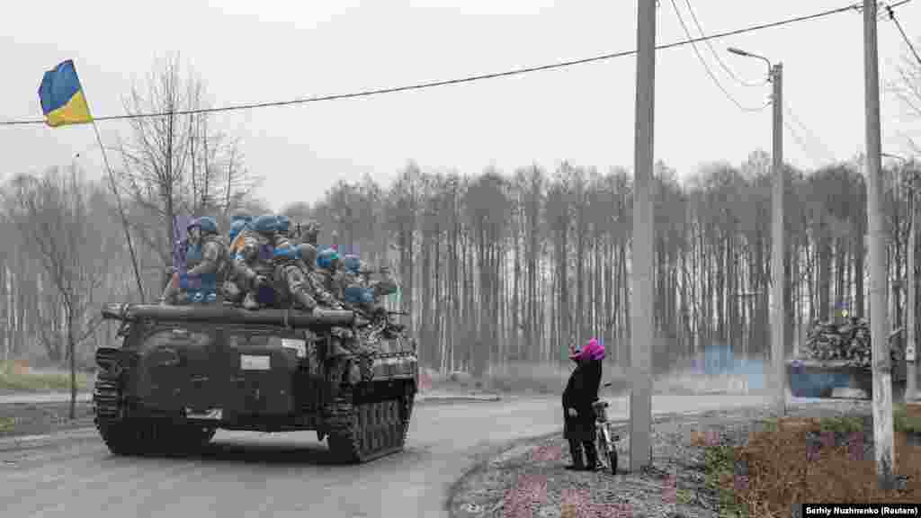 Женщина приветствует украинские войска, въезжающие в освобожденный город на севере Черниговской области, 2 апреля 2022 года