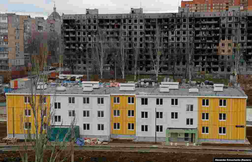 Новостройка напротив разрушенного войной многоквартирного дома. Следственная группа оппозиционера Алексея Навального утверждает, что высшие российские чиновники получают личную прибыль от проектов реконструкции Мариуполя 