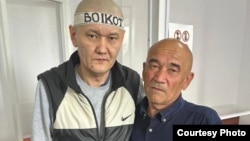 Қамаудағы журналист Думан Мұхаммедкәрім мен оның әкесі Алмаз Тілепов.