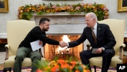 U.S. President Joe Biden (right) shakes hands with Ukrainian President Volodymyr Zelenskiy as they meet in the Oval Office of the White House in Washington on December 12.