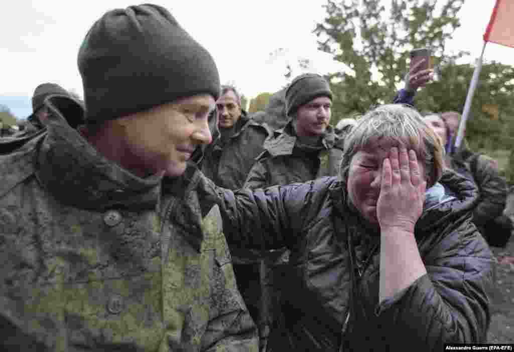 O mamă își salută fiul, un luptător pentru un grup separatist susținut de Rusia, care își spune „Republica Populară Donețk”, eliberat în cadrul unui schimb de prizonieri de război cu forțele ucrainene în localitatea Novoazovsk, regiunea Donețk din Ucraina, pe 21 octombrie 2022. 