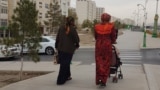 Turkmenistan. Ashgabat. Women walking on empty streets near the residential buildings 
