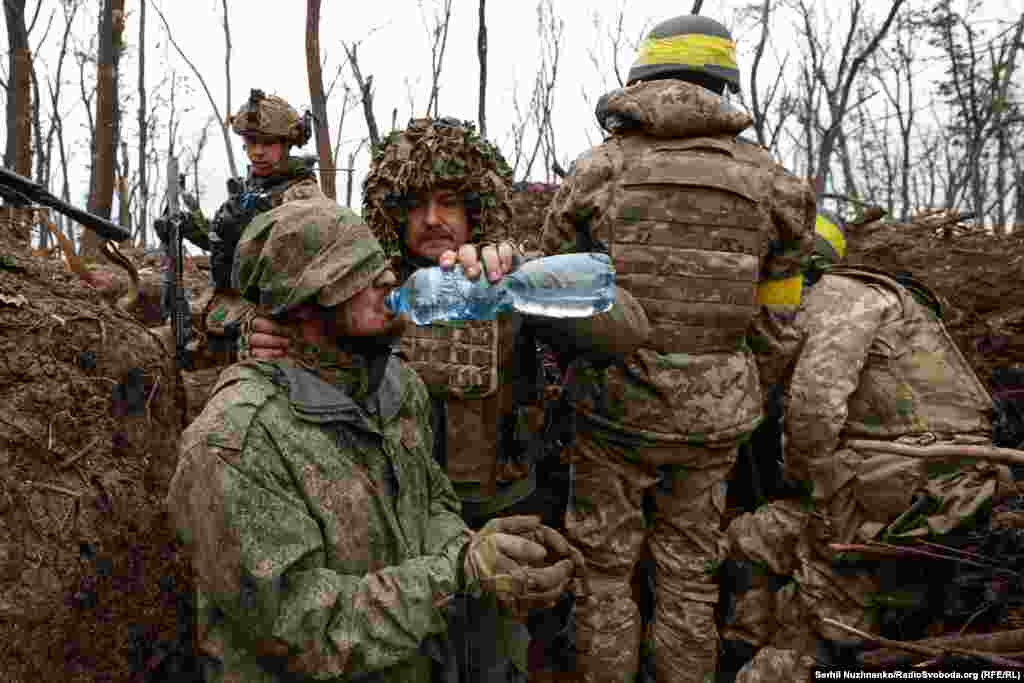Një ushtari rus i jepet ujë pas kapjes së tij nga forcat ukrainase pranë Bahmutit në majin e vitit 2023.