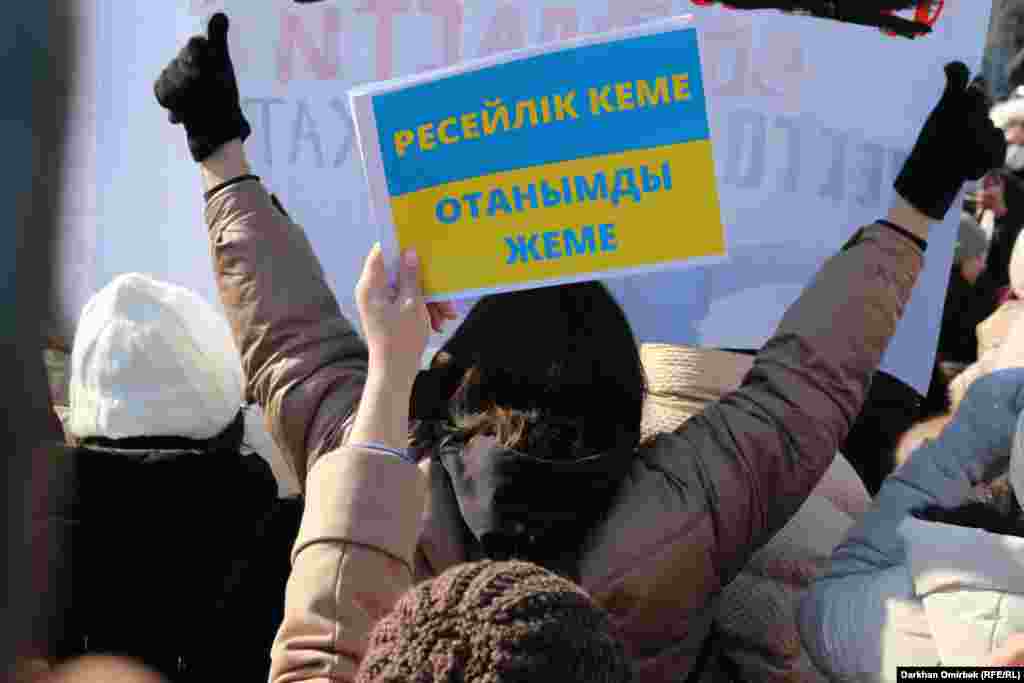 Участница митинга за права женщин держит антивоенный плакат в поддержку Украины, где 17-й день идет борьба против российской оккупации 