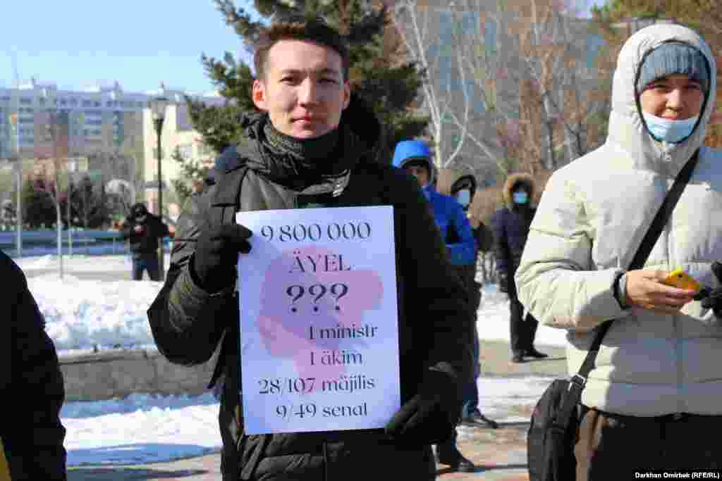 Участник митинга показывает собравшимся, что 9,8 миллиона из 18 миллионов человек, населяющих Казахстан, — женщины. При этом среди министров и акимов только одна женщина, в 107-местном мажилисе женщин — 28, а в сенате, где 49 мест, женщин всего девять 
