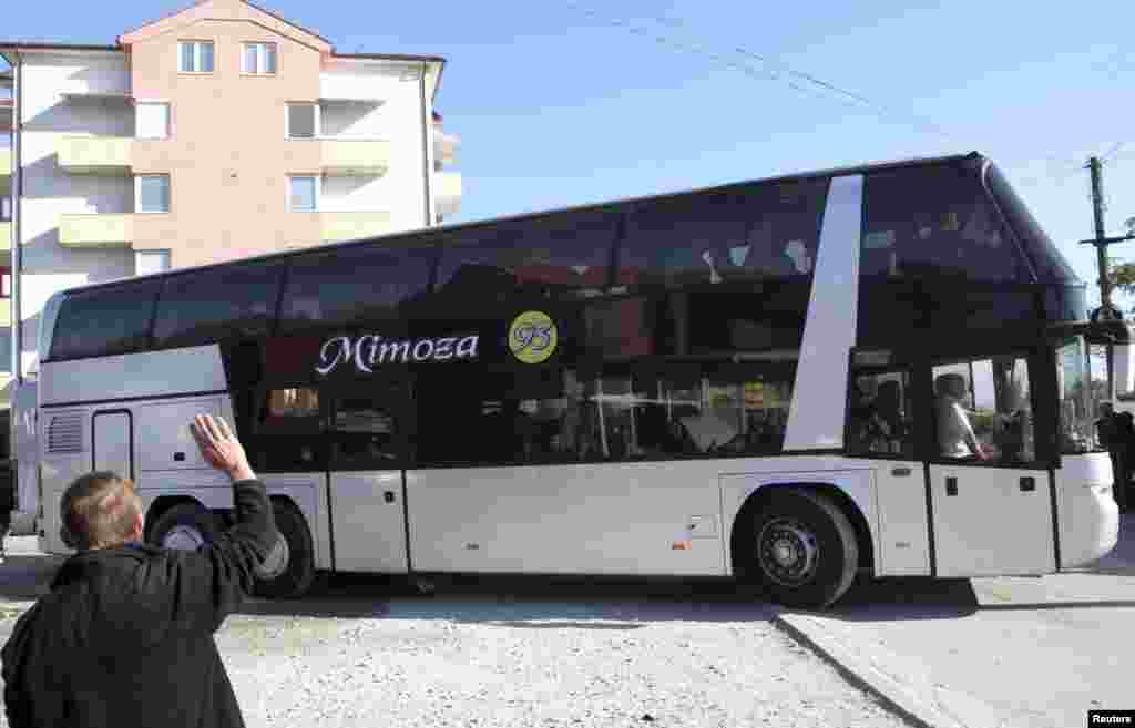 Një burrë përshëndet të afërmit e tij që po nisen...