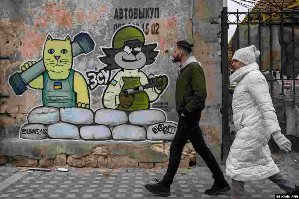 Ky mural, i krijuar nga grupi LBWS, në qytetin-port ukrainas Odesa, është paraqitur me elemente fëmijërore, teksa portretizon seriozitetin e luftës.