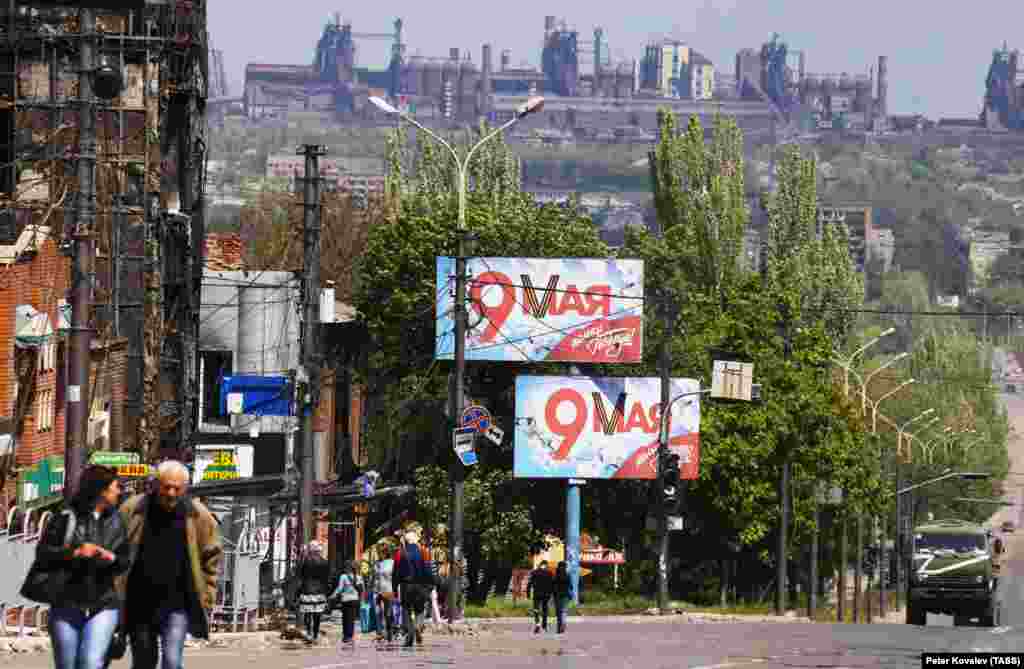 Билборды, прославляющие победу над нацистской Германией во Второй мировой войне, на улицах разрушенного Мариуполя. На заднем плане — «Азовсталь» 