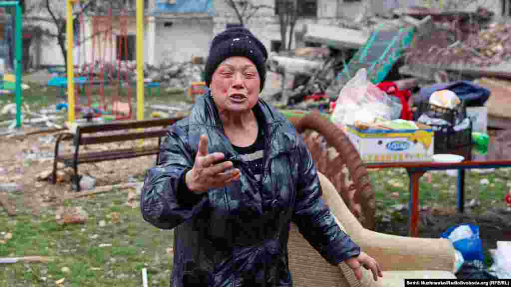 77-річна Марія, чиї донька та зять загинули (тіла ще не знайдені) під завалами будівлі, зруйнованої російськими обстрілами, плаче біля зруйнованої багатоповерхівки 