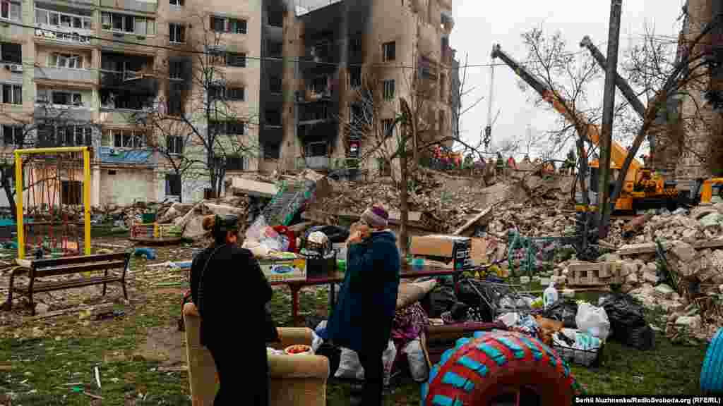 Місцеві жителі харчуються біля свого будинку в Бородянці, зруйнованого російськими авіаударами 