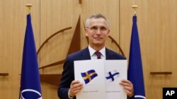 Генеральный секретарь НАТО Йенс Столтенбер держит документы о вступлении Финляндии и Швеции в НАТО