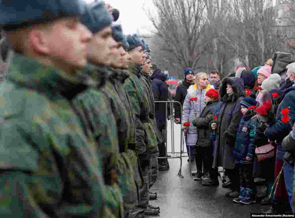 Локални жители и кадети во регионот контролиран од сепаратистичка група поддржана од Русија, која себеси се нарекува Доњецка Народна Република за време на церемонијата на 22 јануари по повод фаталното гранатирање на тролејбус седум години претходно во Доњецк.