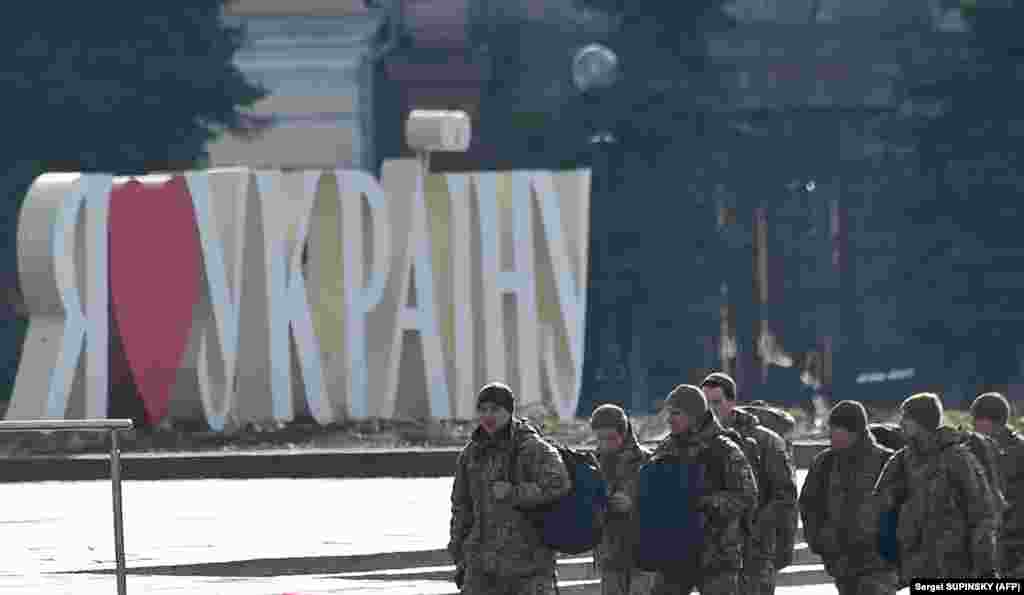 Украинские военные проходят мимо таблички с надписью «Я люблю Украину» на площади Независимости в Киеве, где в 2014 году прошли массовые протесты, приведшие к свержению пророссийского президента Виктора Януковича.