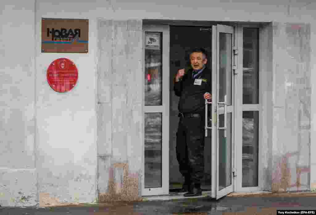 Një roje sigurie, qëndron në hyrje të zyrave të gazetës Novaya në Moskë, më 15 mars 2021. Gazeta tha se një kamerë sigurie, kishte regjistruar një person të panjohur duke spërkatur hyrjen e zyrës me një lëng të panjohur. Një erë e fortë kimike përfshiu ndërtesën dhe ishte e ngjashme me erën gjatë sulmit kundër korrespondentes Yulia Latynina. 