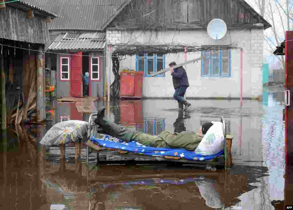 Білорусь – чоловік лежить на ліжку під час весняного паводку в селі Хвоєнськ, 14 квітня 2013 року