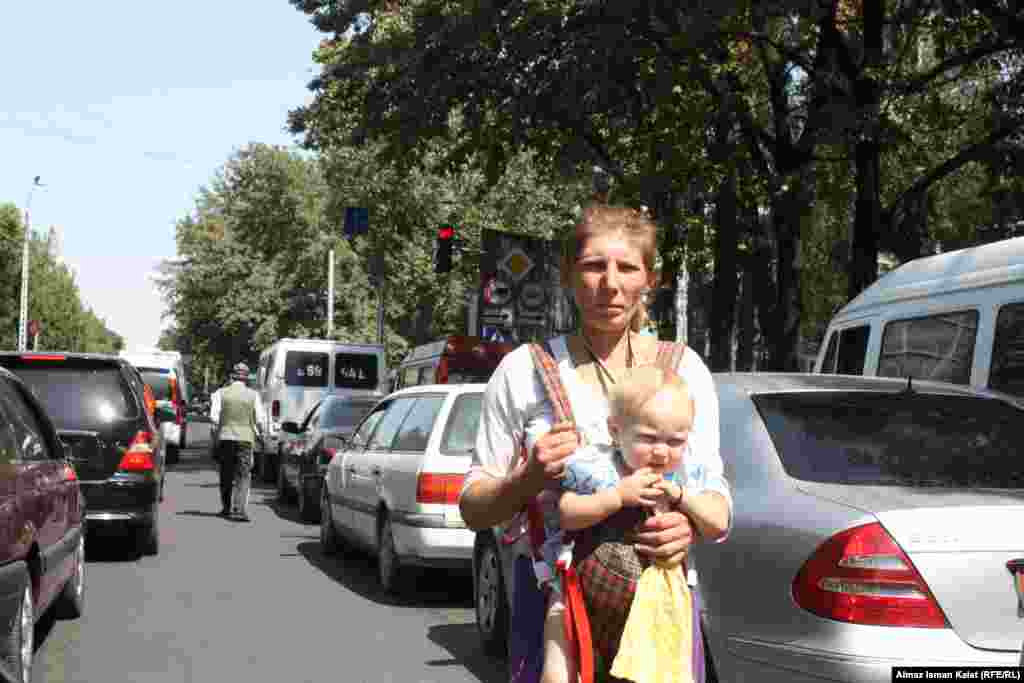 Женщина с ребенком на улицах Бишкека в поиске пропитания.
