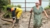 Співробітник &laquo;Крим-Спас&raquo; і жінка у дворі підтопленого будинку