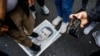 Демонстрант стоит на фотографии президента Башара Асада во время акции протеста у сирийского консульства в Стамбуле, 8 декабря 2024 года. 
