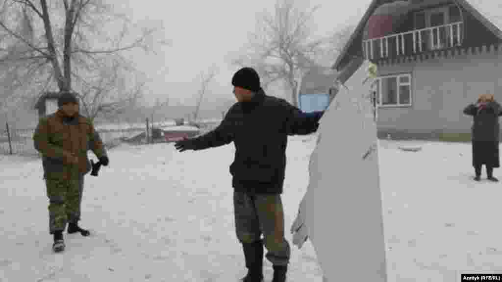 Ұшақ сынығын ұстап тұрған тұрғындардың бірі. 