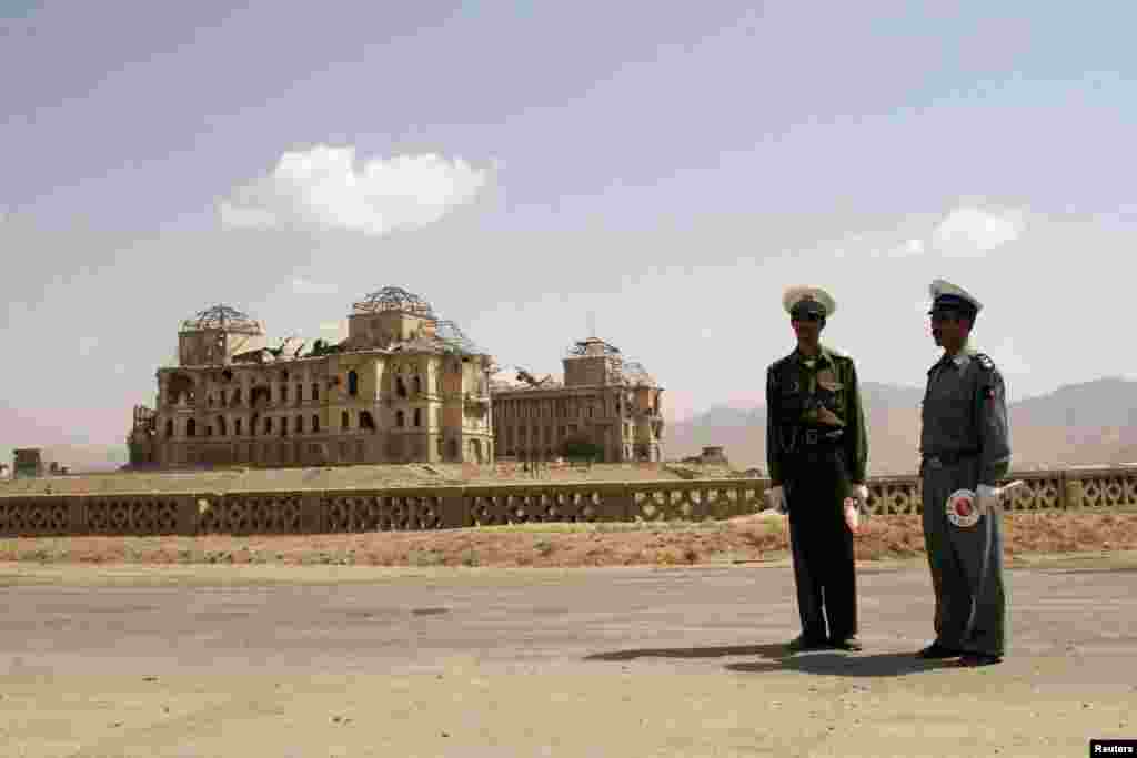 Afghan traffic police stand near Kabul's destroyed King's Palace in August 2005, one month before historic parliamentary and provincial elections created the country's first legislature based on the ballot.