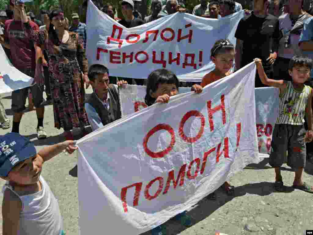 Ребенок держит плакат с надписью – «ООН помоги!», в лагере беженцев на узбекской границе. 19 июня 2010 года.