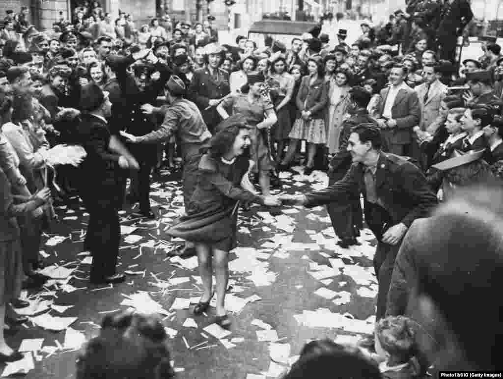 Британки и американские солдаты танцуют в Лондоне 8 мая 1945 года, через день после капитуляции нацистской Германии. 
