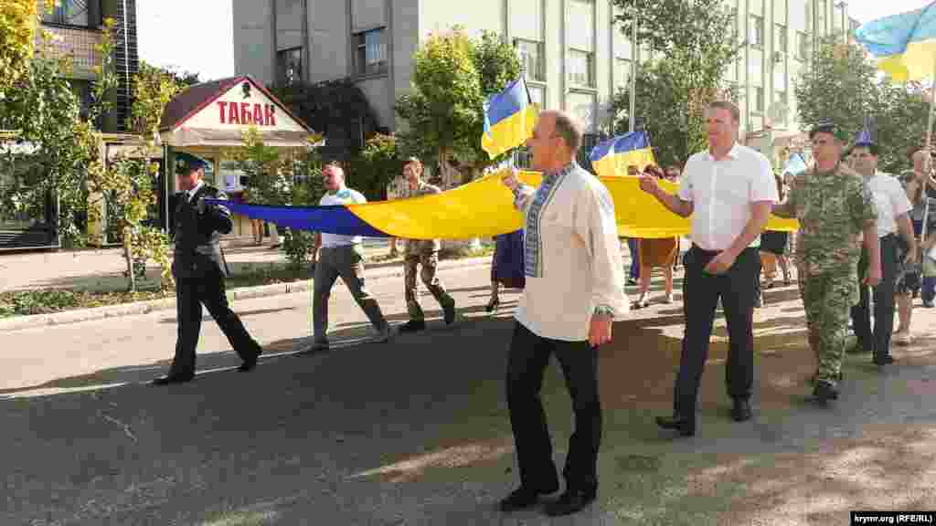 Yürüş iştirakçileri şeer soqaqlarından milliy urbalarda Ukraina bayraqları ile keçtiler