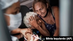  Женщина получает прививку китайской вакцины Sinovac CoronaVac в центре вакцинации в Рио-де-Жанейро, Бразилия 2021. 