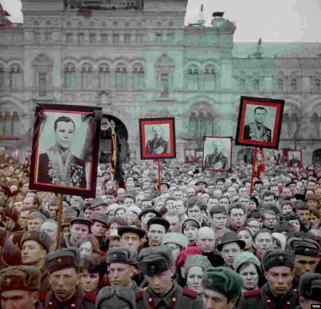 Люди несут фотографии Гагарина и Серёгина в день их похорон на Красной площади. 