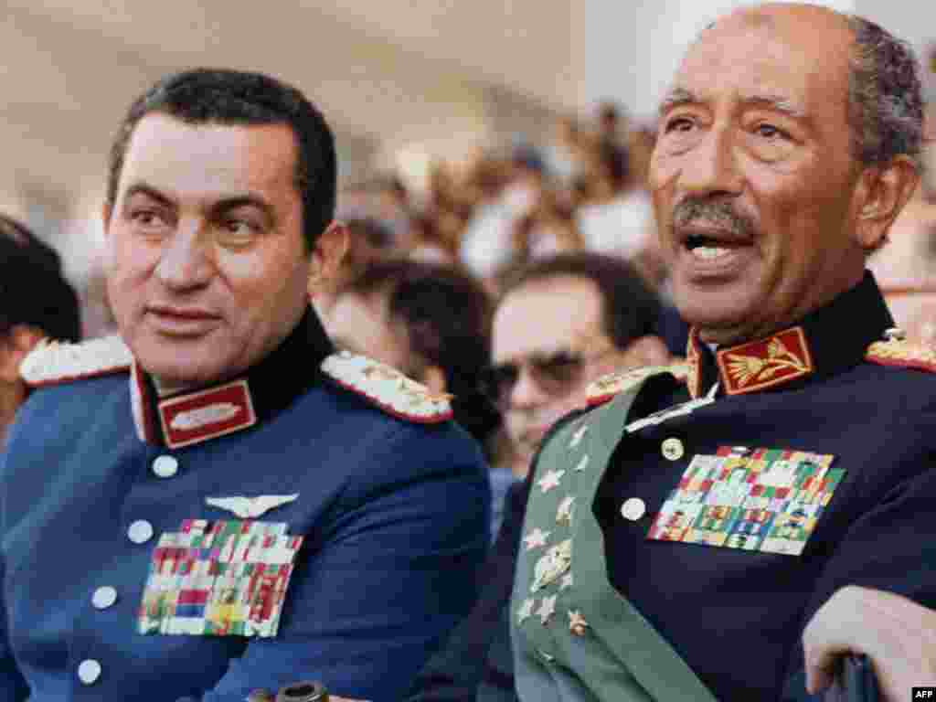 В то время вице-президент Египта, Мубарак с президентом Анваром Садатом - Мубарак и Садат на военном параде в Каире 6 октября 1981 года, во время которого Садат был убит группой исламских фундаменталистов