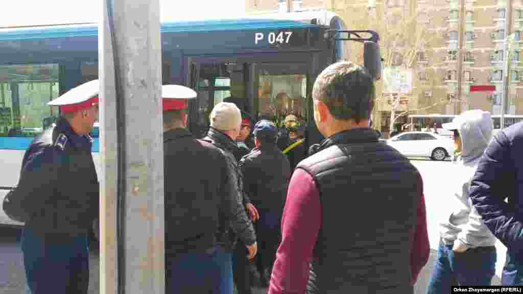 Полицейские заводят в автобус задержанных участников протеста. Нур-Султан, 1 мая 2019 года.