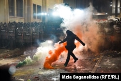 Maskaly polisiýa işgäri 29-njy noýabrda Tbilisidäki parlament binasynyň alnynda tüsse granatyny aýagy bilen zyňýar. Şol döwürde Gürjüstanyň hökümeti Ýewropa Bileleşigine girmek baradaky gepleşikleriň ýatyrylandygyny yglan etdi.