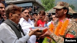 People present sweets to Pakistan Army soldiers as part of celebrations following the announcement of a cease-fire between India and Pakistan, in Chakothi village in Pakistan-administered Kashmir on May 11.
