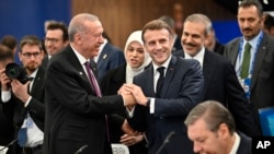 Turkish President Recep Tayyip Erdogan (left) shakes hands with French President Emmanuel Macron at a plenary session during the European Political Community (EPC) summit in Budapest in November 2024.