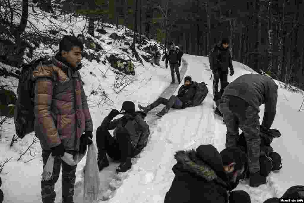 Një grup migrantësh afganë bëjnë pushim ndërsa ecin nëpër male në një zonë që besohet të jetë e minuar gjatë luftës në Bosnje. 