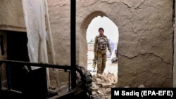An Afghan security official inspects the scene of a suicide bomb attack in Kandahar on December 7, 2020.