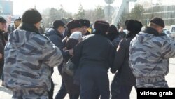 Полиция мен күштік құрылым өкілдері әкімдік алдына келген адамды ұстап әкетіп барады. Астана, 21 наурыз 2019 жыл.