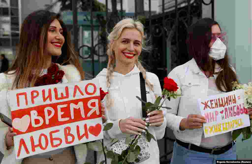 Жени присуствуваат на митингот во Москва на 15 август за да покажат солидарност со белоруските демонстранти. Транспарентот од лево гласи: „Дојде време за љубов“. На оној од десно пишува: „Жените се за мир и љубов. Да живее Белорусија“.