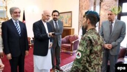 FILE: Afghan President Ashraf Ghani (2 - L) granting an Afghan Army soldier, Esa Khan (C) with the keys to a new flat in recognition of his bravery in June 2015.