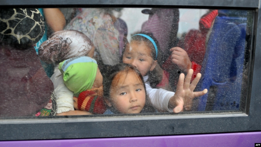 Children in Osh look out the window of a bus as they wait for evacuation to Bishkek on June 17.