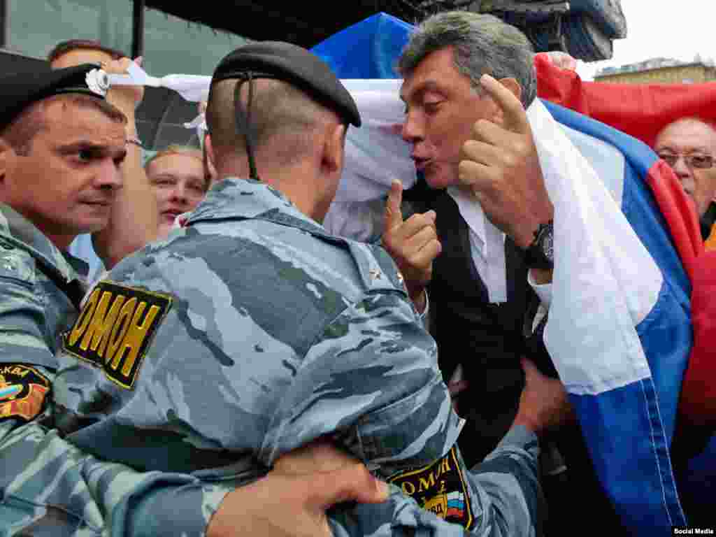 Полицейский хватает Немцова во время марша оппозиции в Москве в 2010 году.