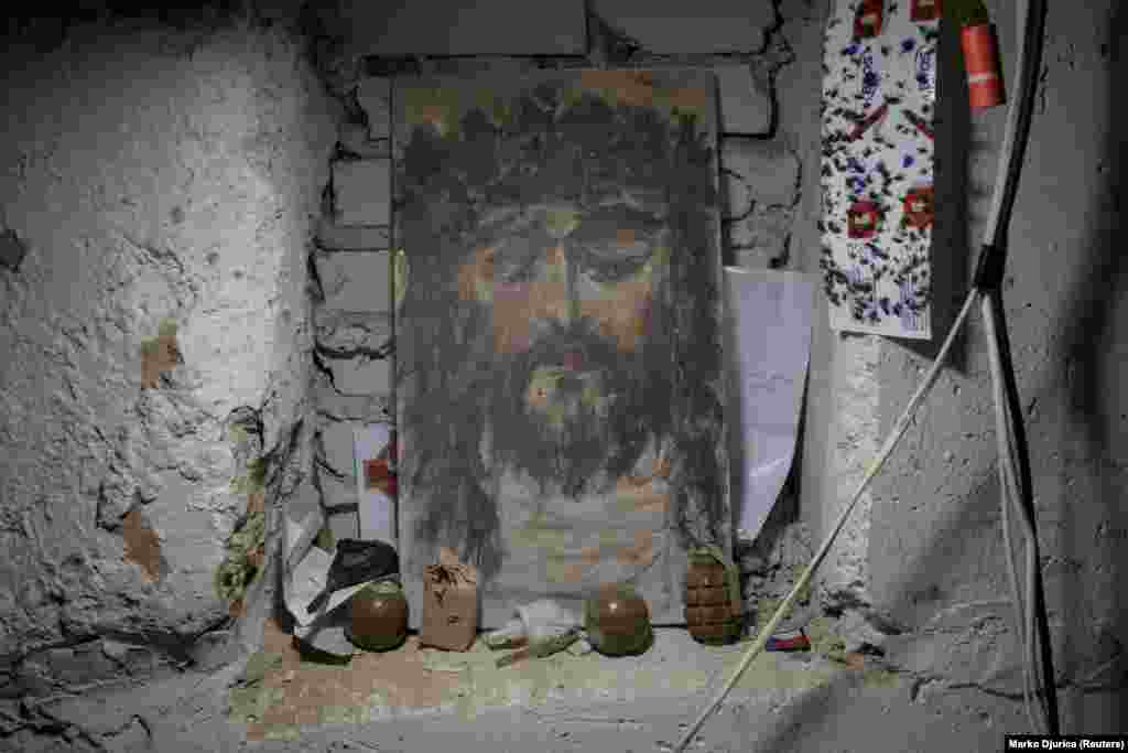 Христостун cүрөтүнүн алдында коюлган гранаталар. Харьков облусундагы фронттогу "Карпатская Сечь" батальонунун алдыңкы операциялык базасы.