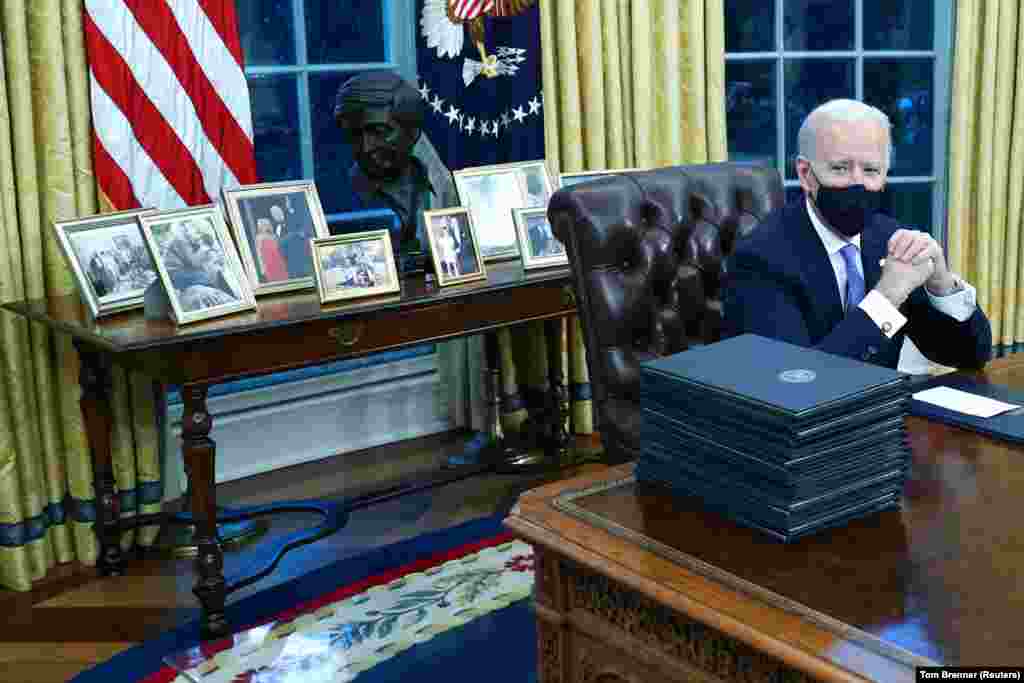 Az elnök azonnal munkához látott beiktatása után. Ezen a képen is éppen több dokumentumot készül aláírni az úgynevezett "Resolute Desk" mellett.