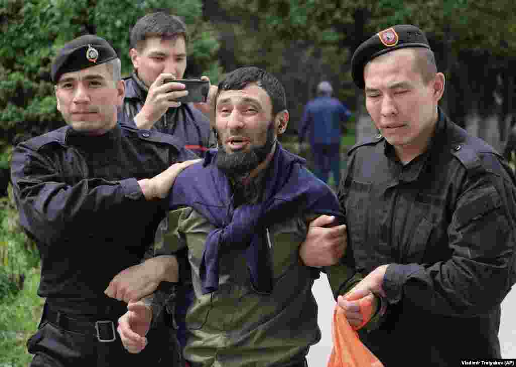 Полиция "Астана" алаңында жүрген адамдардың бірін әкетіп барады. Алматы, 10 маусым 2019 жыл. 